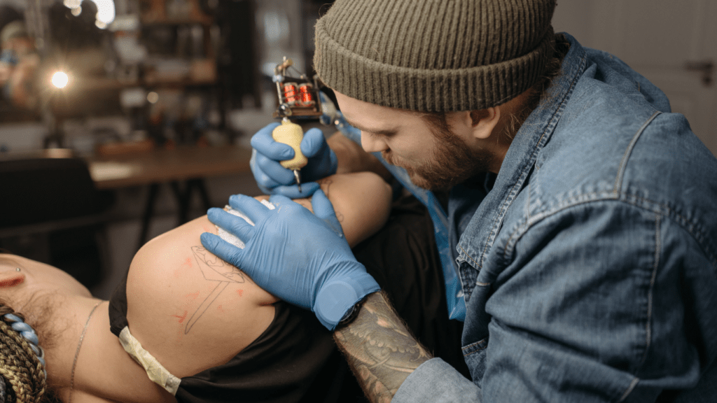 man doing tattoo on arm