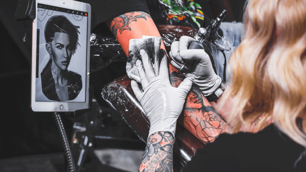 woman tattooing arm